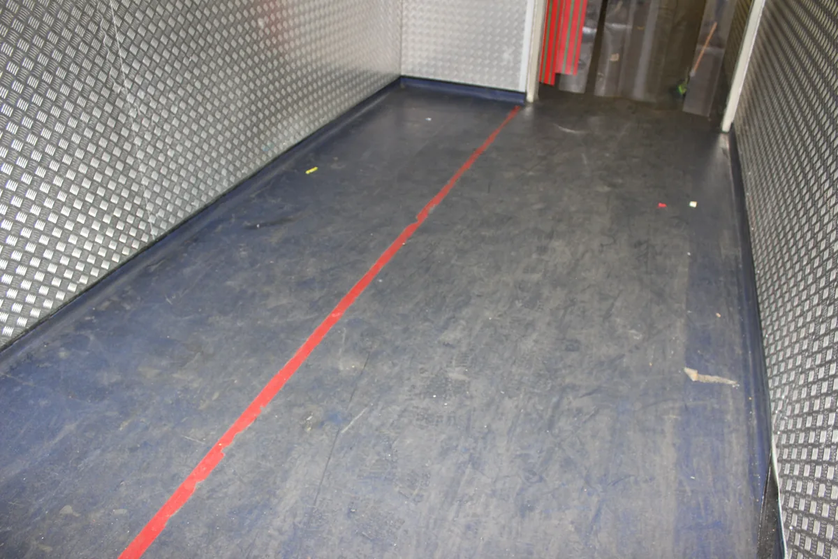 A chiller corridor floor scuffed and marked before the clean