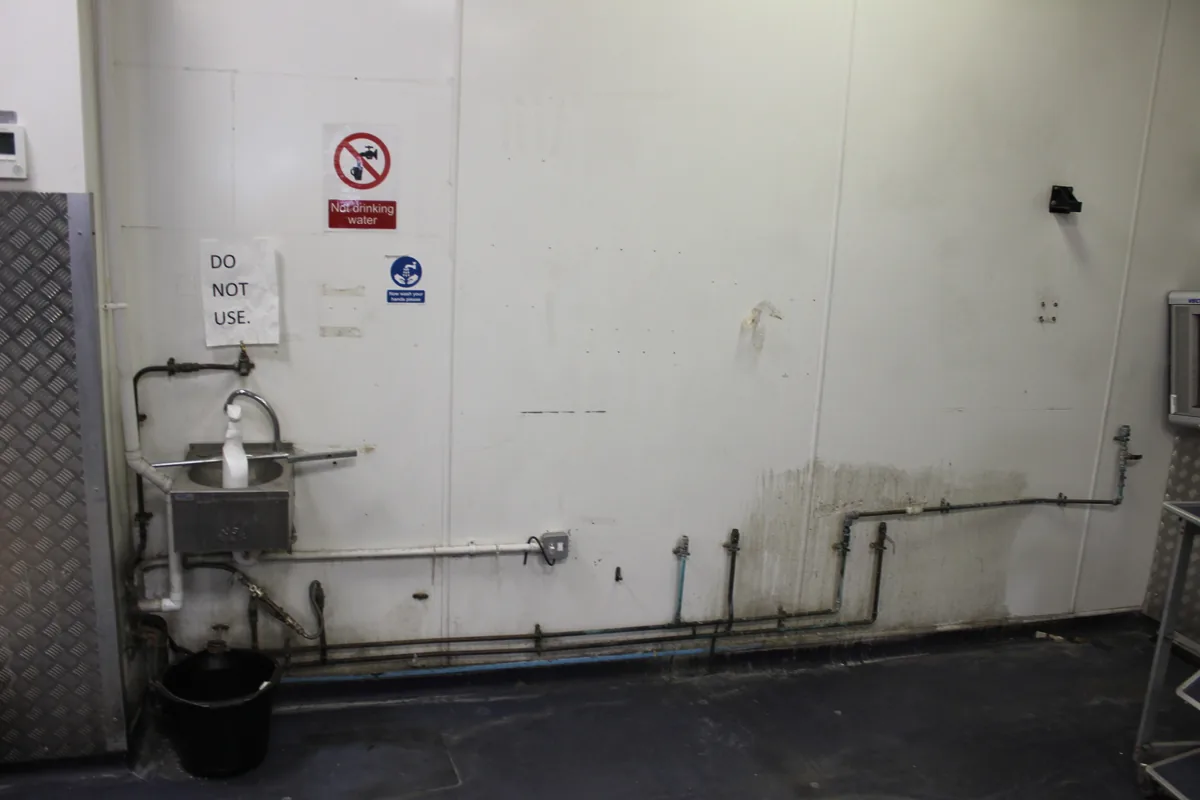A wall and its pipework marked and streaked before the clean