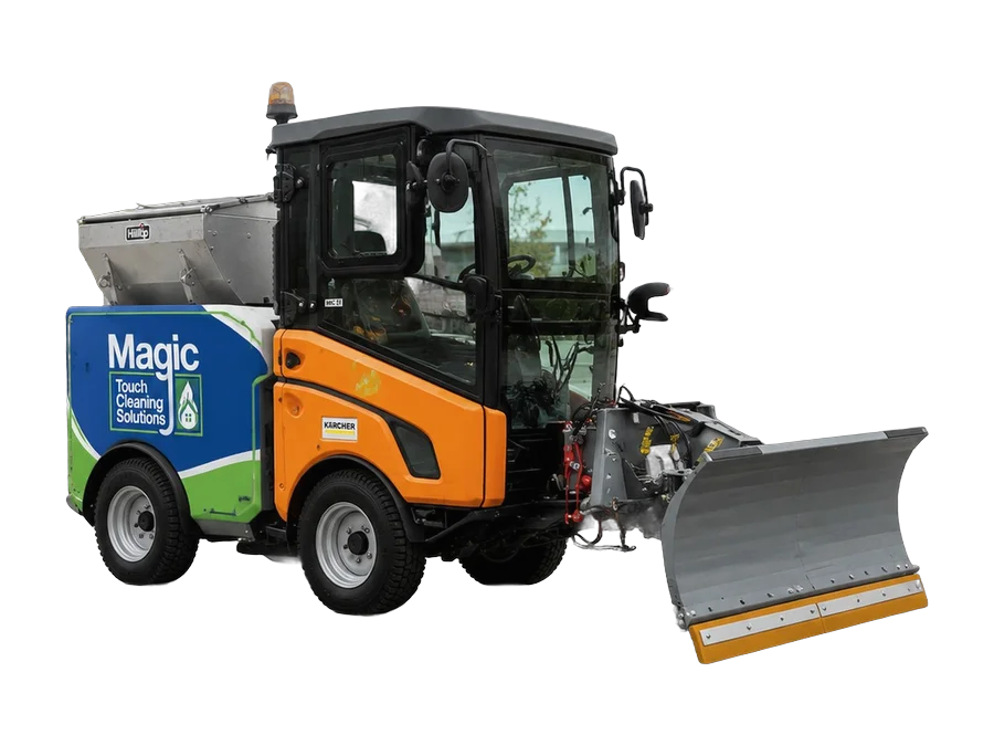 A Kärcher MIC 35 implement carrier fitted with a snow plough and a salt spreader, in Magic Touch livery.